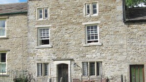 A stone building with multiple windows and a door.