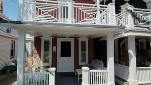 A two-story house with a balcony, a front porch, and a garage. - FALL 2026 Gorgeous Renovation-Walk to Beach, Asbury, Pets Welcome! (Neptune Township)