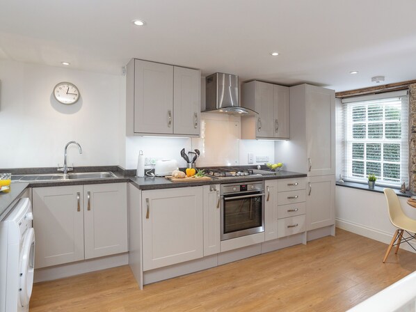 A modern kitchen with a built-in oven, a sink, and a stove.