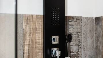 Um chuveiro moderno com um chuveiro manual e um painel de controle fixado na parede.