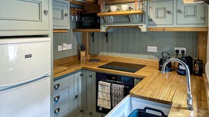 Eine kompakte Küche mit Einbauofen, Spüle und Holz Arbeitsplatten.
