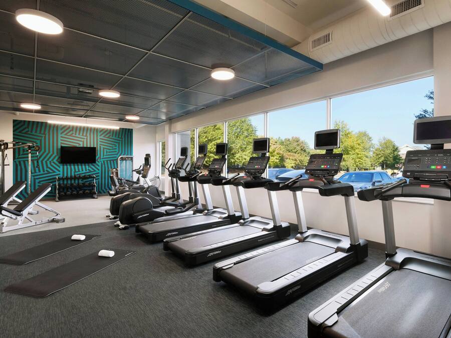 Ein Fitnessstudio mit Laufbändern, Fahrrädern und Krafttrainingsgeräten.