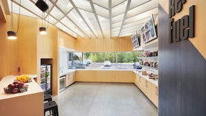 A modern kitchen with a view of the street, wooden cabinets, and a sign reading "re-fuel". - Aloft by Marriott Atlanta Perimeter Center (Atlanta)