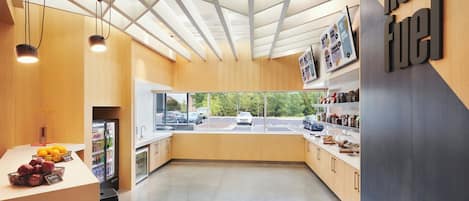 A modern kitchen with a view of the street, wooden cabinets, and a sign reading "re-fuel".