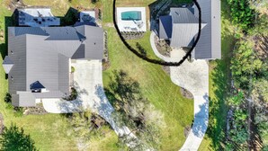An aerial view of a residential area with two houses, a swimming pool, and a curved driveway. - "Bee Keeper's Cottage" on private estate, new construction, close to everything! (Sarasota)