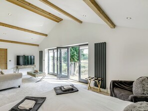 Une chambre moderne avec un grand lit, une télévision et une vue sur l’extérieur.