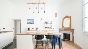 A modern kitchen with a central island, bar stools, and a fireplace. - Le Saint Firmin - Two Bedroom Apartment, Sleeps 4 (Montpellier)