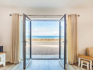 A room with a glass door leading to a beach view. - 4 bedroom accommodation in Waters Edge, near Banff (Waters Edge, near Banff)
