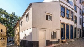 A corner building with a beige facade, a small door, and windows. - Downtown Cosy House by Host Wise (Porto)