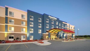 Um hotel com vários andares, uma entrada imponente e estacionamento.