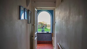 A hallway with a view of a garden through an arched doorway. - 3 bedroom accommodation in Clynnog Fawr (Clynnog Fawr)