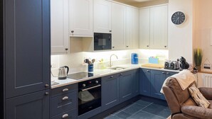 A modern kitchen with white cabinets, a microwave, a sink, and a toaster.
