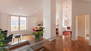 Un salón espacioso con piso de madera, una mesa de comedor y una escalera que sube a un nivel superior.