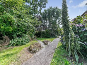 A gravel path surrounded by lush greenery and flowering plants.