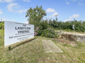 Señalización para 'The Land's End Vineyards' que indica alojamiento vacacional con servicio de comidas.