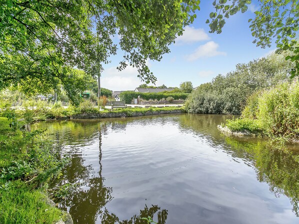 A calm river with a bench and greenery.