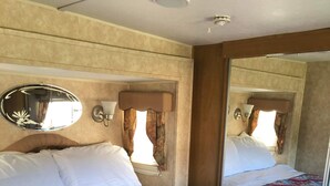 Een hotelkamer met een groot bed, een spiegel en een raam met gordijnen.