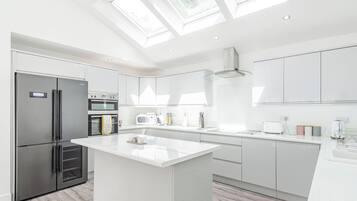 A modern kitchen with a central island, built-in appliances, and skylights.