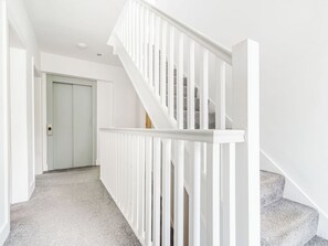 A staircase with white railings leading to a door.