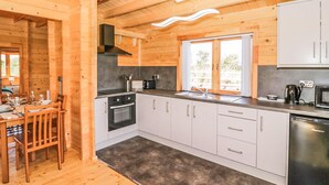 Eine moderne Küche mit Holzwänden, einem eingebauten Backofen, einer Spüle und einem Geschirrspüler.
