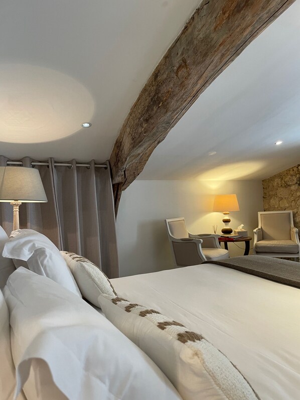 A hotel room with a large bed, two chairs, a small table, and a lamp. - La Maison du Clocher (Saint-Émilion)