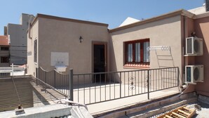 A residential building with a balcony, a window with curtains, and an air conditioning unit. - Caminito en Planta Alta (Salta)