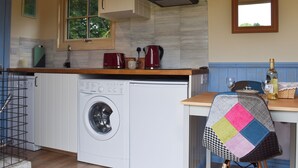 A compact kitchen with a washing machine, a coffee maker, and a window. - 1 bedroom accommodation in Herstmonceux, near Hailsham (Herstmonceux, near Hailsham)