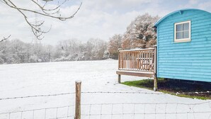 A blue wooden structure with a bench, surrounded by a snow-covered field and trees. - 1 bedroom accommodation in Herstmonceux, near Hailsham (Herstmonceux, near Hailsham)