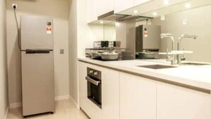 A modern kitchen with a built-in oven, a refrigerator, a sink, and a microwave. - MONTLY OFFER 3BR 3 Min Walk KLCC FREE WIFI 6 PAX (Kuala Lumpur)