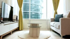 A modern living room with a flat-screen TV, a glass coffee table, and a sofa. - MONTLY OFFER 3BR 3 Min Walk KLCC FREE WIFI 6 PAX (Kuala Lumpur)