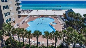 Ein Hotel mit Pool, umgeben von Palmen und Blick auf den Strand.