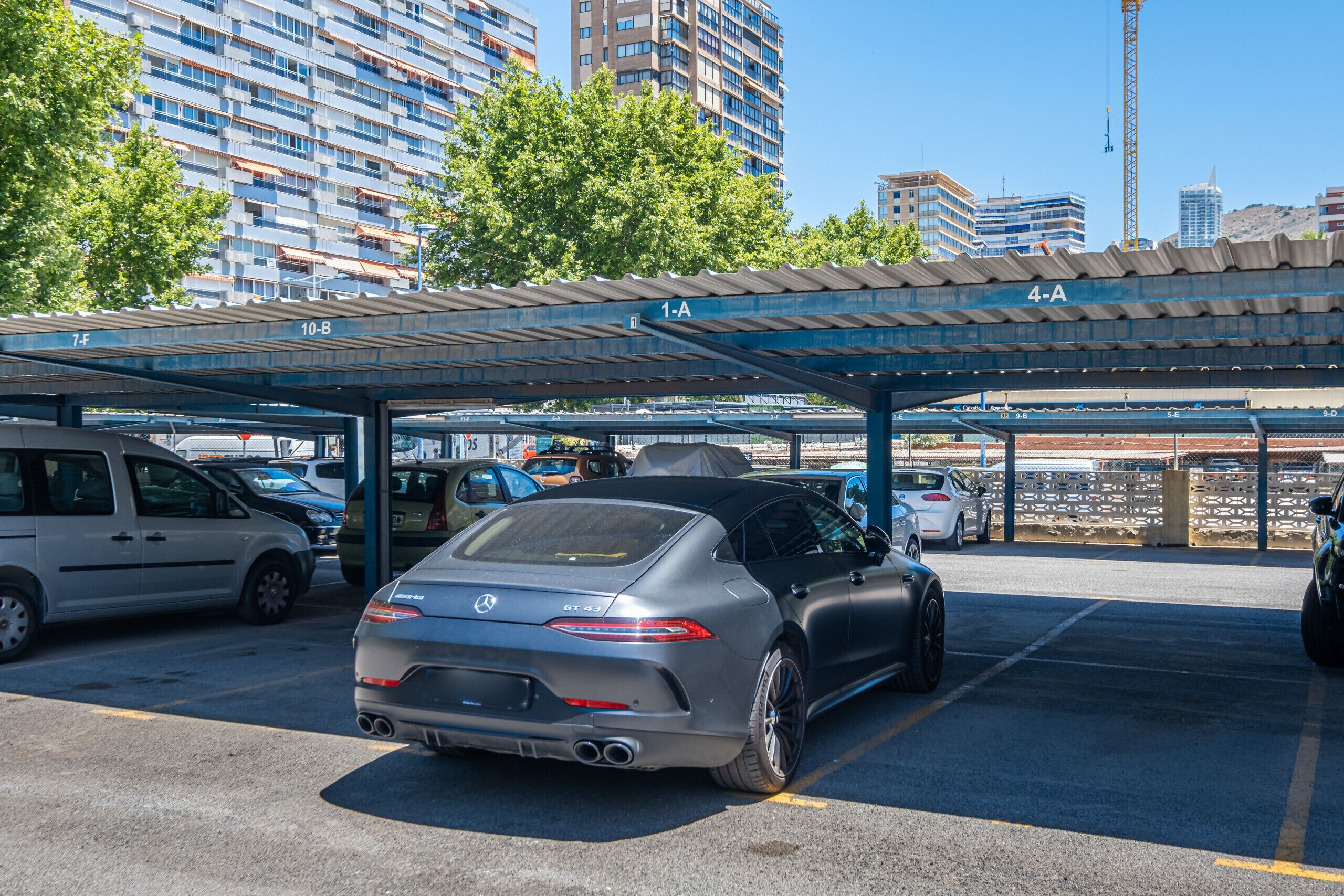 Un espace de stationnement où est garée une Mercedes-Benz GT 3.5, à l’abri sous une structure couverte.