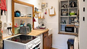 A compact kitchen with a stove, oven, microwave, and a small sink. - The best things certainly come in small parcels and Bloomer’s Bothy has it all. (Woodhall, near Askrigg)