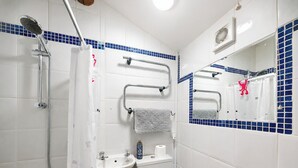 A bathroom with a shower, sink, toilet, and a mirror with a towel rack. - The best things certainly come in small parcels and Bloomer’s Bothy has it all. (Woodhall, near Askrigg)
