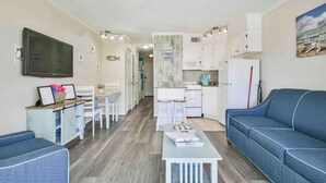 A compact living space with a dining area, kitchenette, and seating area.