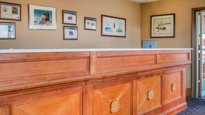 A reception desk with framed certificates on the wall. - Mackinac Lodge (Mackinaw City)