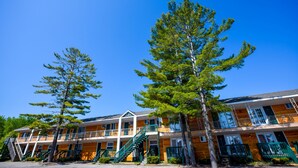A multi-story motel with a central staircase, wooden exterior, and balconies. - Mackinac Lodge (Mackinaw City)