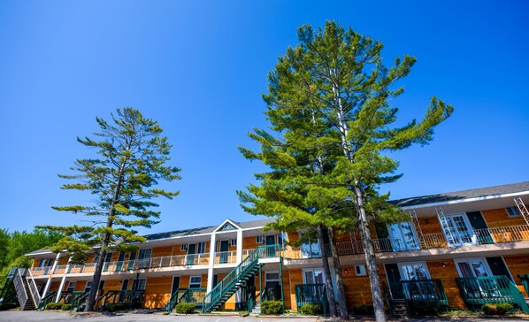 A multi-story motel with a central staircase, wooden exterior, and balconies.