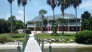 A large, two-story house with a covered porch and a pathway leading to the entrance.