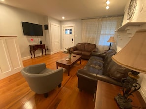 Relax in this stylish living room with a comfortable sofa, armchair, and flat-screen TV.