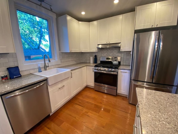 Enjoy cooking in this well-equipped kitchen with a refrigerator, oven, and dishwasher, and take in the view from the large window.