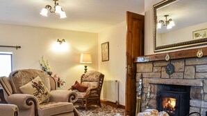 A cozy living room with a fireplace, comfortable seating, and a table set for tea.
