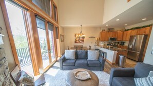 A spacious living room with a gray sofa, ottoman, and a dining area with a table and chairs. - Antlers Gulch 104 (Keystone)