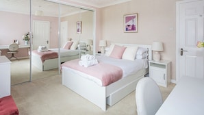 A modern bedroom with a large bed, bedside tables, a desk, and a chair. - 4 bedroom accommodation in Brodick (Brodick)