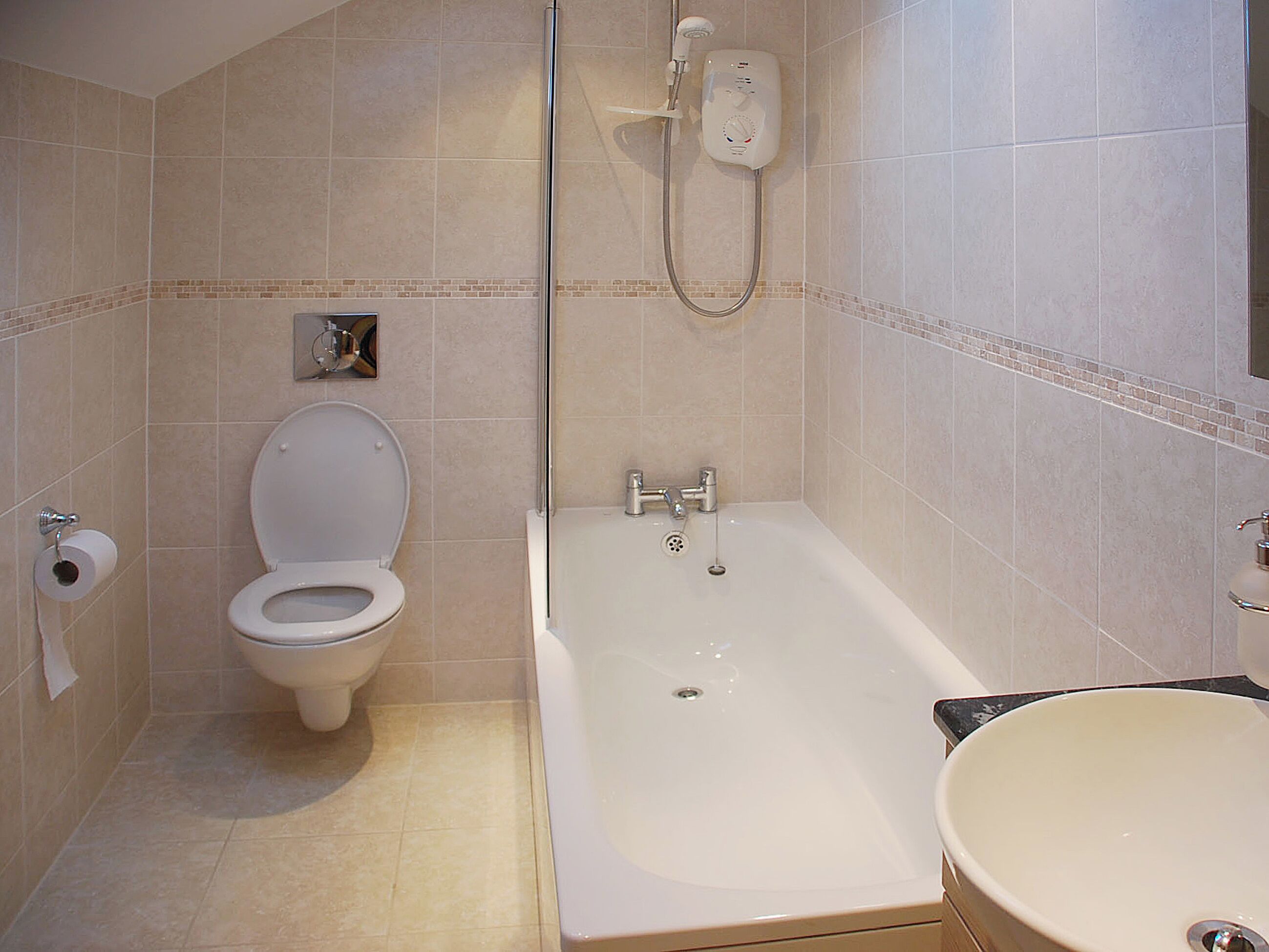 Une salle de bain avec des toilettes, une baignoire et un lavabo.