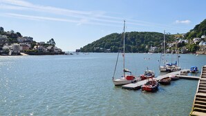 A harbor with boats docked, a pier, and buildings on a hillside. - 1 bedroom accommodation in Dartmouth (Dartmouth)