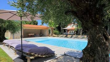 Ein Schwimmbecken mit Liegestühlen und einer Pergola.