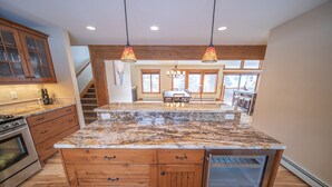 A spacious kitchen with granite countertops, wooden cabinetry, and a central island. - Enclave 29 (Keystone)