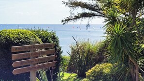 Un senyal de fusta amb indicacions cap a diferents zones del jardí i on trobar coses per menjar i beure.
