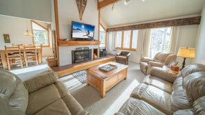 A spacious living room with a fireplace, comfortable seating, and large windows. - Quicksilver 1618 (Keystone)